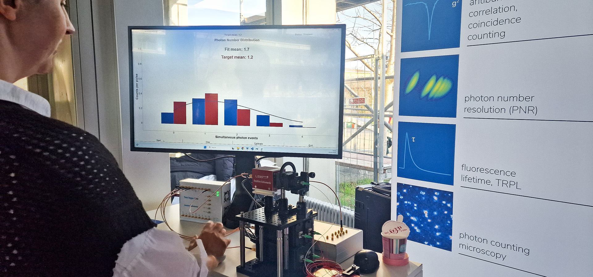 Photon number distribution demo setup from Swabian Instruments at the DPG SAMOP 2026 conference in Mainz showing a pulsed laser controlled by the Pulse Streamer sends photons through a beam splitter to four single-photon detectors, with data recorded and visualized in real time using the Time Tagger Ultra. On a monitor, the measurement is displayed as a Poissonian photon-number distribution. The x-axis shows how many detectors register photons at the same time, while the y-axis shows the counts per pulse.