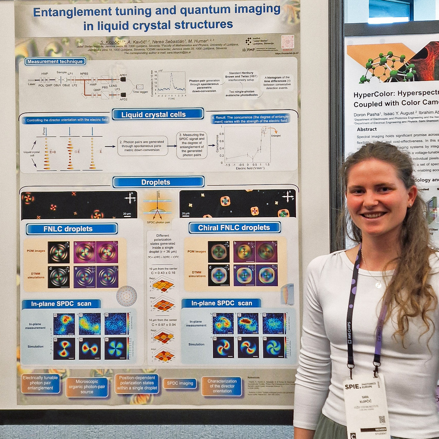 Sara Klopčič standing next to her poster at SPIE Photonics Europe, presenting research on quantum entanglement tuning and imaging in liquid crystal structures using a Time Tagger Ultra from Swabian Instruments.